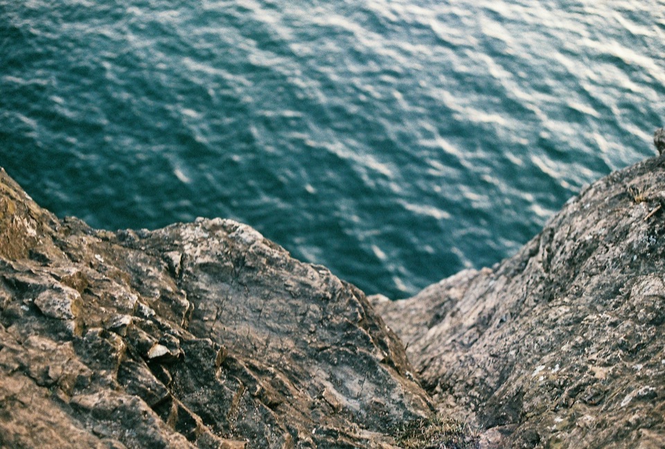 Rock formations meeting blue water